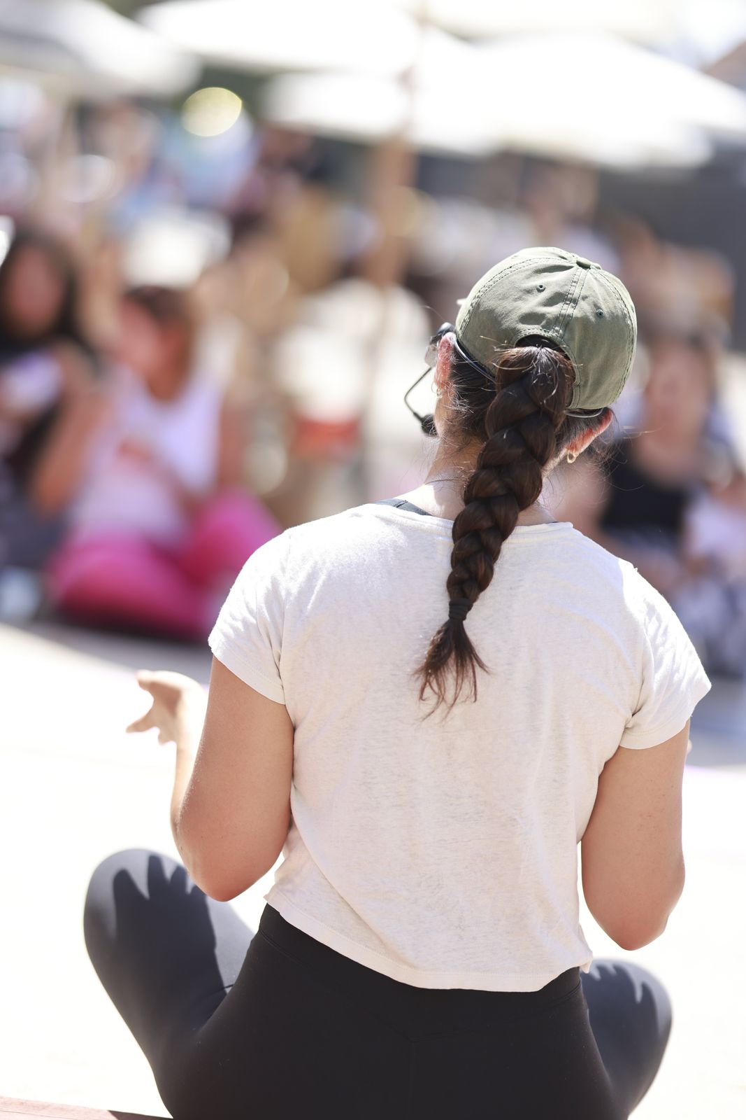 Miwa seen from behind, with a long braid, guiding the group seated on mats.