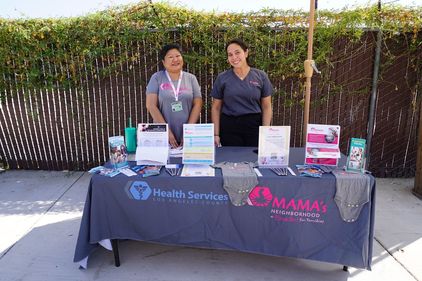 Two staff members at the LA County Department of Health Services MAMA's Neighborhood resource table.