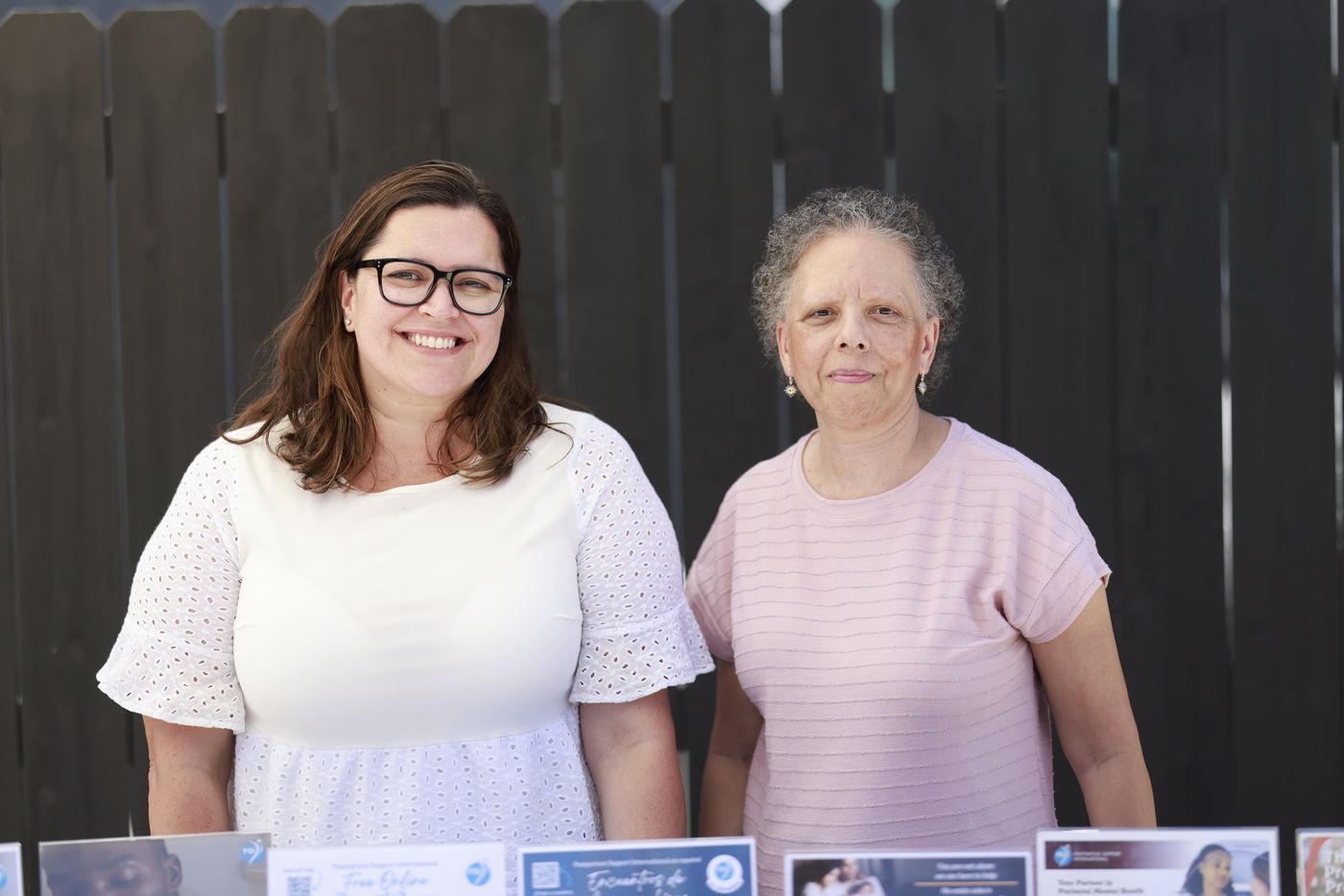 Two volunteers from the California chapter of Postpartum Support International standing at their resource table.