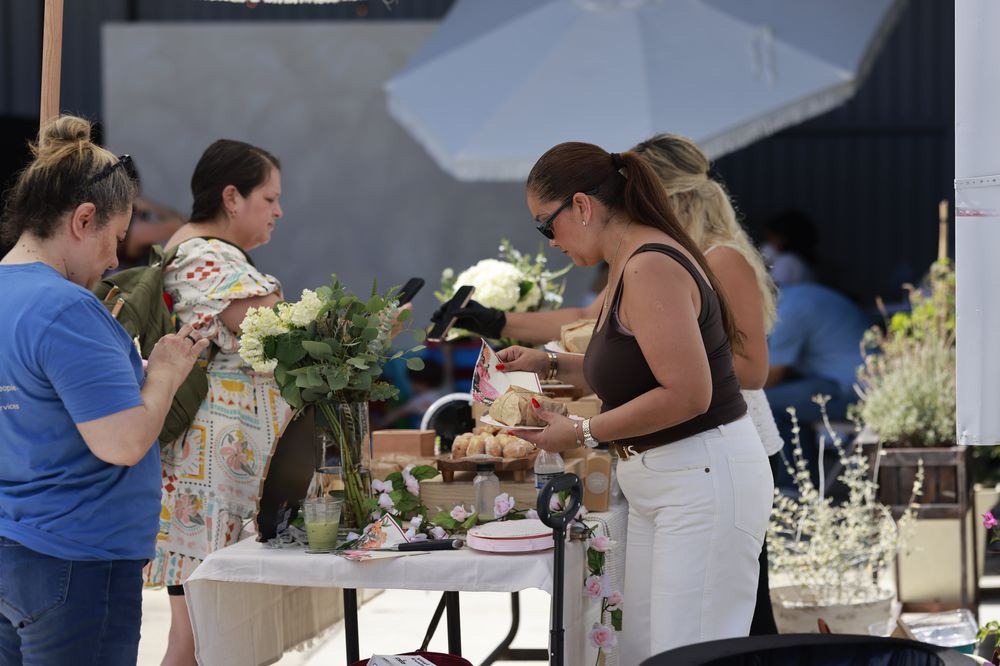 Moms choosing pastries at a table with white flowers at Mothering the Mother.